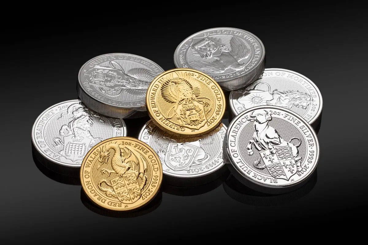 Moedas de prata e de ouro sobre fundo escuro